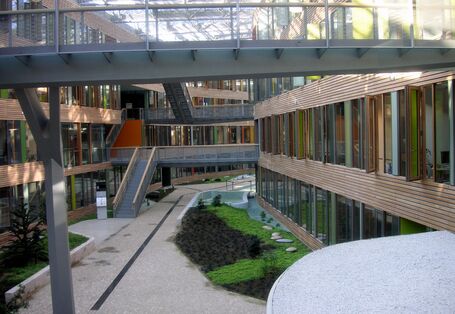 atrium with a glass roof, bridgesElongated inner courtyard with glass roof, skywalks linking two sides of the building, greenery and water basin
