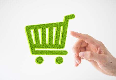Hand tippt auf das Piktogramm eines grünen Einkaufswagens