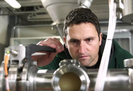 Ein Mann prüft eine Maschine in einer Werkshalle