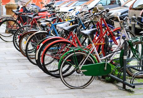 viele bunte Fahrräder in Fahrradständern abgestellt