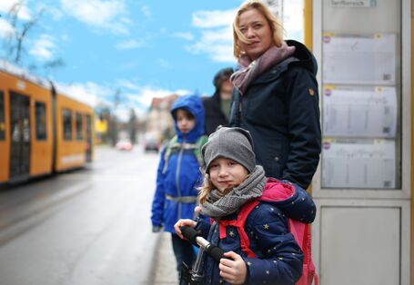 Familie an der Straßenbahnhaltestelle
