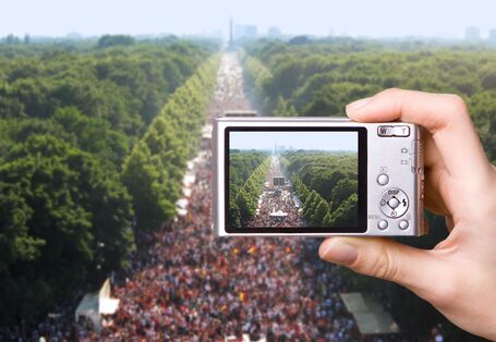 Digitalkamera fotografiert eine Großveranstaltung auf der Berliner "Straße des 17. Juni", rechts und links der baumbestandene "Große Tiergarten"