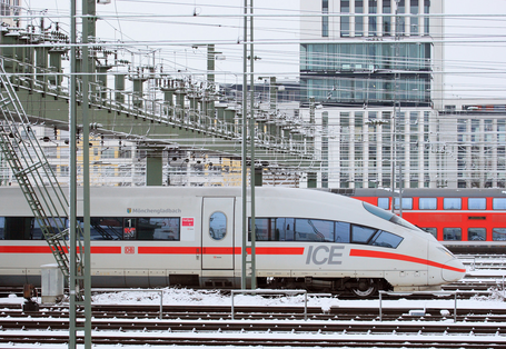 moderner ICE-Schnellzug auf einem verschneiten Gleis in der Stadt