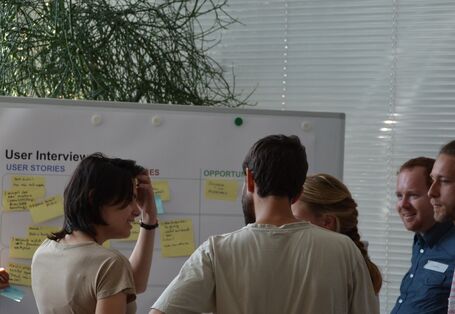 Teilnehmerinnen und Teilnehmer eines Workshops vor einem Flipchart