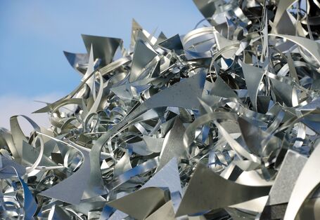 ein Man mit Bauhelm steht vor einer Landschaft mit Tagebau und einem Bagger