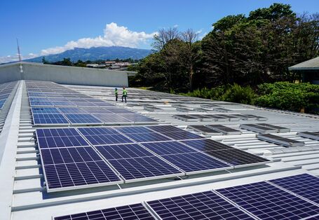 A photovoltaic system is installed on the roof of a warehouse