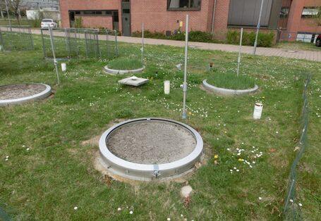 Eine Wiese mit mehreren runden Messbehältern