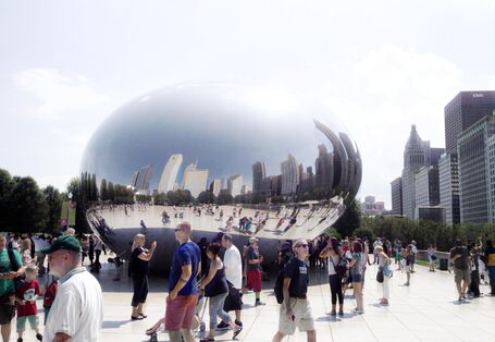 Skulptur eines riesigen metallenen "Wassertropfens" auf einem Platz in Chicago, drum herum viele Menschen, die diese besichtigen und fotografieren.