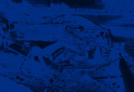 Müllverladung auf Kähne: Mehrere Arbeiter schaufeln Müll direkt auf Kähne im Hafen