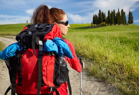 Frau mit Outdoorjacke und Rucksack beim Wandern