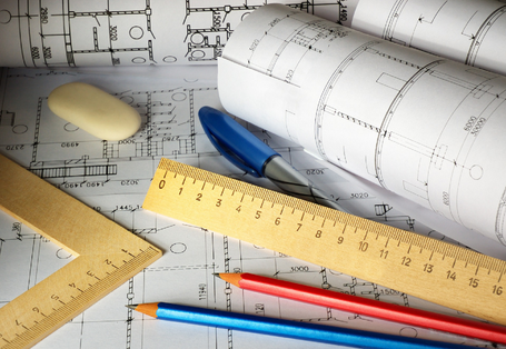 Schreibtisch bedeckt mit Schreib- und Zeichenutensilien