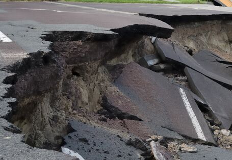Nahaufnahme einer frischen Rutschung an einer Asphaltstraße.