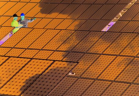 Two engineers discussing in an extensive photovoltaic installation