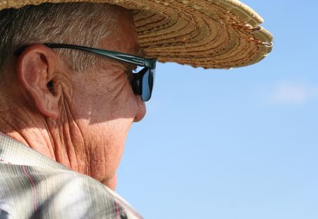 Älterer Mann mit Strohhut und Sonnenbrille