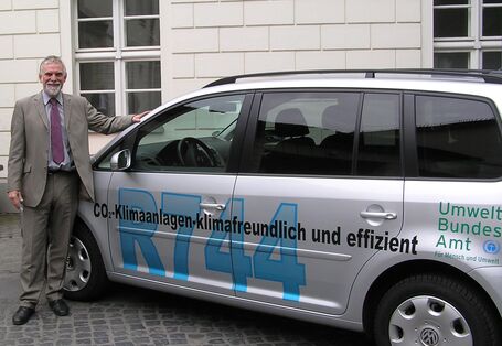 The former UBA´s President Jochen Flasbarth beside a silver VW Touran with the inscription "R744"