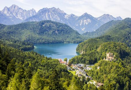 A lake with mountains around it and blue sky.