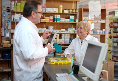 Foto von Beratungssituation am Tresen in einer Apotheke. 