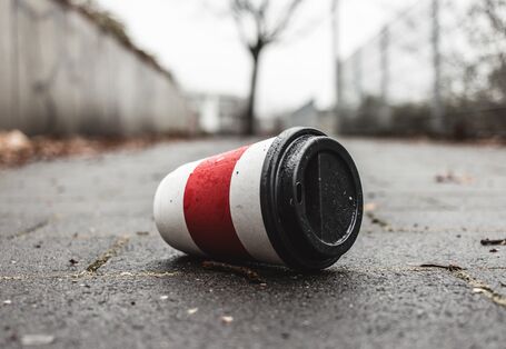 Ein Coffee-to-go-Becher liegt auf der Straße