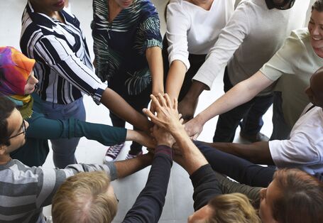 Personen legen die Hände aufeinander