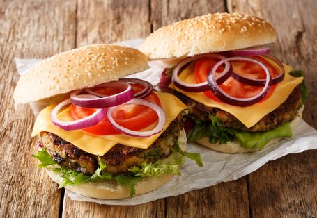 Zwei vegetarische Hamburger liegen auf einem Holzbrett