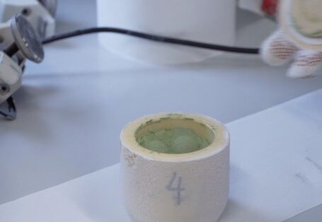 Grünes Pulver in einem Tiegel.