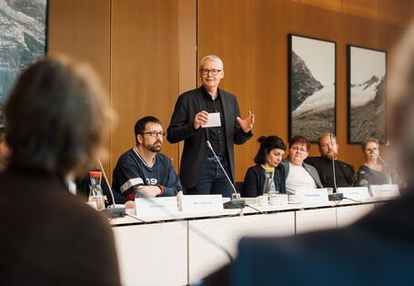 Ein Herr im dunklen Anzug steht und spricht