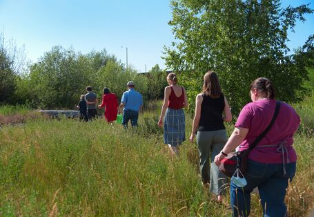 Menschen laufen durch hohes Gras