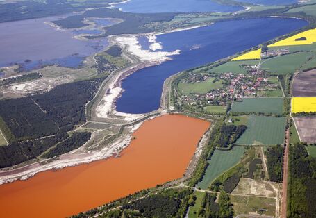 Luftbild einer Landschaft mit Tagebausee