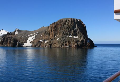 •	Icebergs and rugged cliffs jut out of the water around the Antarctic Peninsula 