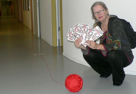 Christiane Keppler hockend mit Garnrolle & Schriftschablonen