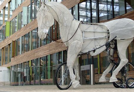 ein großes Pferd, gefertigt aus einem Gestell mit Papier bespannt, mit eingebauten Rädern & Fahrrad-Vorrsichtung