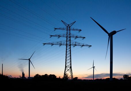 Stromstraße aus Windkraftanlagen in der Abenddämmerung