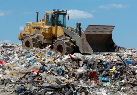 Ein Bagger auf einer Mülldeponie