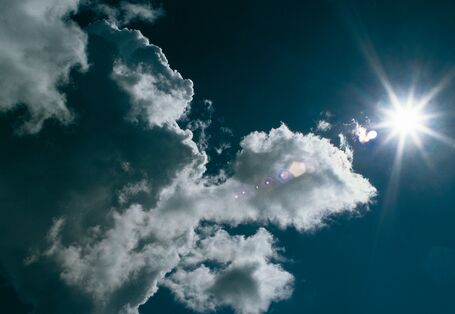 Blauer Himmel mit Sonne und Wolken