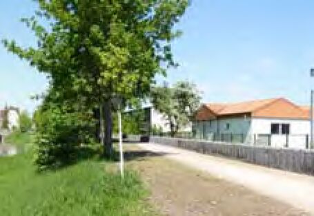 Eine Steinmauer steht schützend vor Häusern