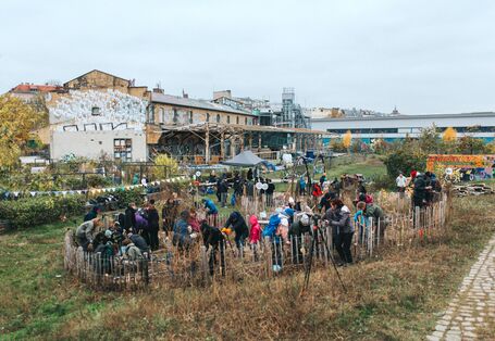 Pflanzaktion im Stadtgarten im Herbst. Im Vordergrund Menschen, die junge Bäume pflanzen, im Hintergrund das ZK/U-Gebäude.