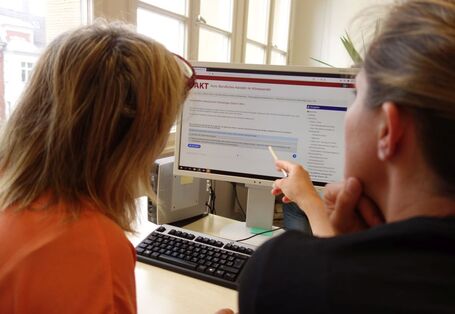 Zwei Personen schauen sich auf einem Computerbildschirm die Online-Tools des Projekts an.