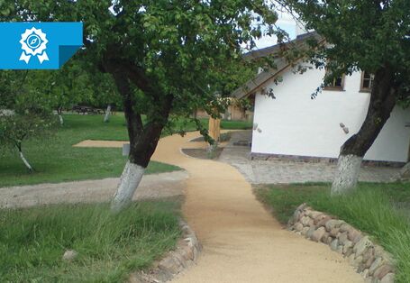 Ein Foto einer nicht-asphaltierten Wegkreuzung vor einem Haus.