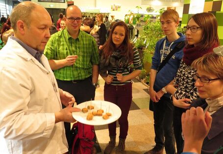 Mehrere Veranstaltungsbesucher stehen um den Anbieter von veganen Lebensmitteln.