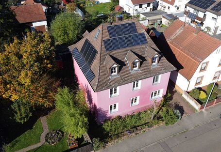 Ein rosarotes Wohnhaus von oben.