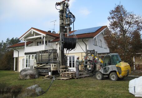 Ein Bohrgerät vor dem freistehenden Einfamilienhaus