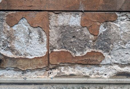 Ein aufgehendes Mauerwerk, dessen Oberfläche durch den Einfluss von Umweltfakturen partiell zurückgewittert ist. 