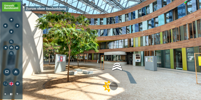 Screenshot aus dem virtuellen Rundgang durch das UBA-Gebäude Dessau, ein modernes Bürogebäude mit viel Glas, Holz, farbig gestalteten Flächen und einem bepflanzten Atrium