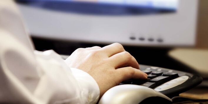 Anschnitt eines Monitors, Nutzung von Tastatur und Maus durch Person