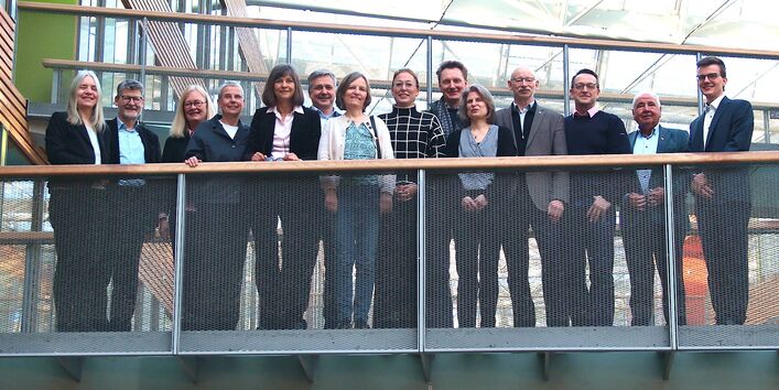 Gruppenfoto von 14 Personen auf einer Brücke