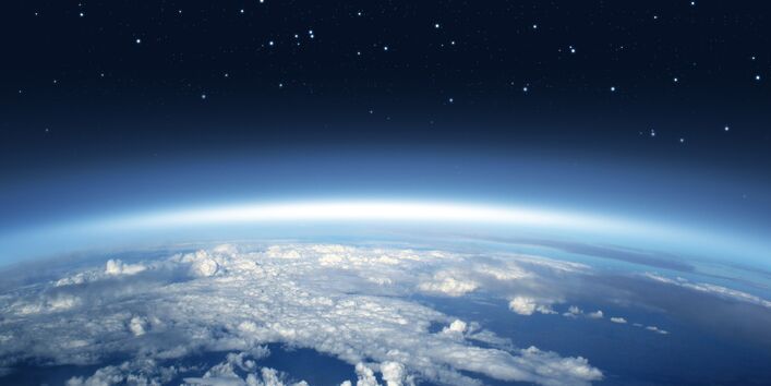 Photo showing the atmosphere high above the Earth, with clouds below and stars above