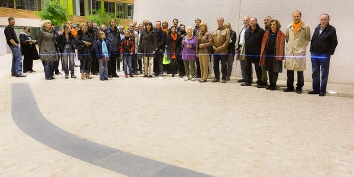 Im Atrium des UBA Dessau steht eine Gruppe von Personen. Etwa in Hüfthöhe zeigt ein blauer Laser den Stand des Wasserpegels.