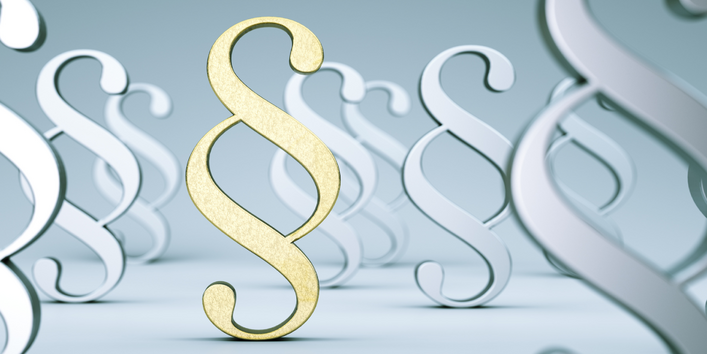 Paragraphen-Symbole in gold und silber im Raum stehend