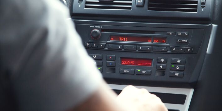 Ein Mensch sitzt im Auto. Die Klimaanlage im Auto ist auf 22 Grad Celsius eingestellt.