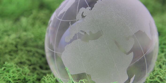 The picture shows a modell of the earth in green gras.